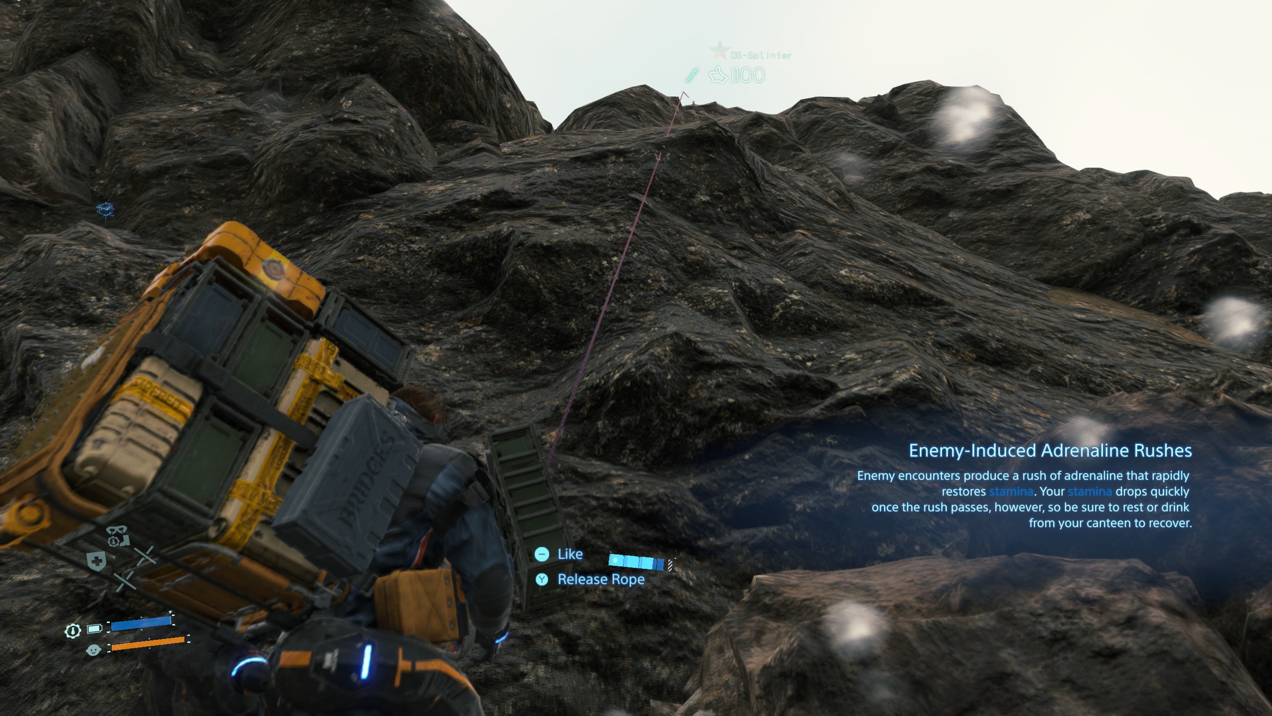 A picture of Death Stranding gameplay, showing the protagonist Sam Porter Bridges attempting to climb a sheer cliff face using a rope that another player left behind
