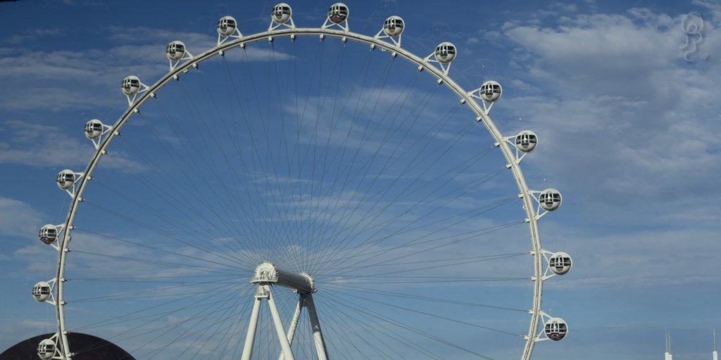 An image of The ferris wheel in downtown Las Vegas, as taken from a camera facing away from the strip through hotel tinted windows